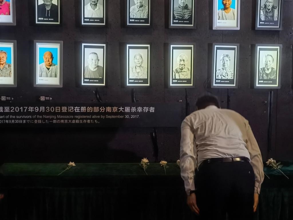 7月18日，人們向離世的南京大屠殺幸存者獻花、鞠躬。新華社記者邱冰清 攝