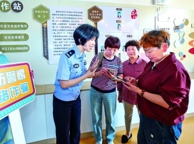 浙江湖州民警指導(dǎo)居民加入湖州“e企安”微信群，實(shí)時(shí)接收反詐信息。新華社發(fā)