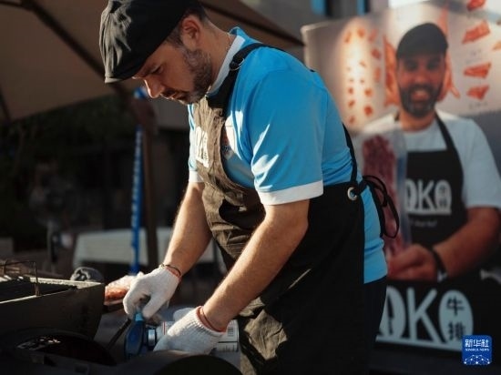 7月19日，在蕪湖古城，馬丁在當(dāng)天舉行的啤酒節(jié)上制作牛排。新華社發(fā)（繆雨晨 攝）