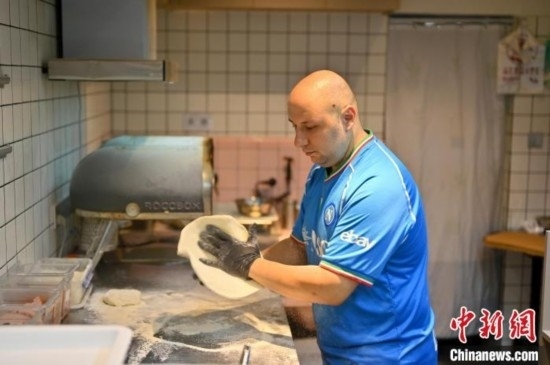 近日，韋榮耀在自家披薩小店內(nèi)忙活。俞靖 攝