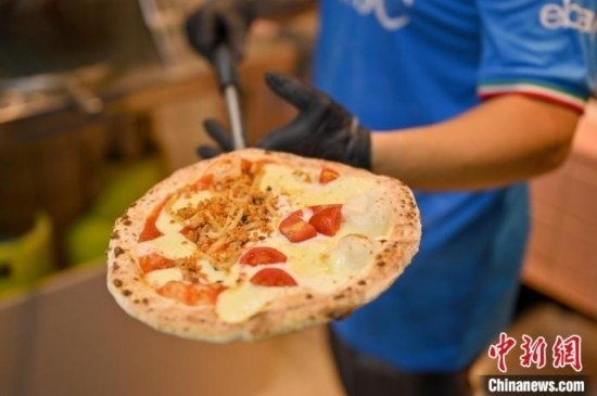 近日，韋榮耀展示他制作的“老友味”披薩。 俞靖 攝