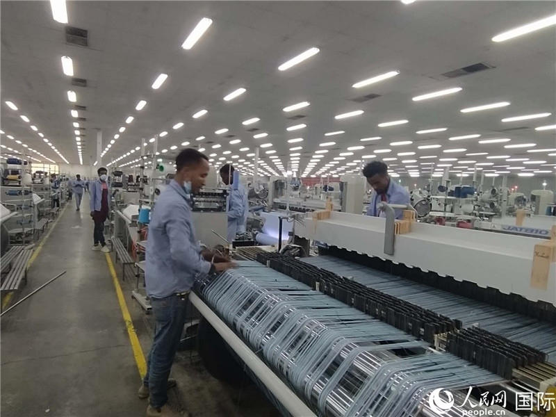 無錫金茂埃塞面料廠車間內(nèi)，當(dāng)?shù)毓と苏谝唤z不茍地作業(yè)。人民網(wǎng)記者 黃培昭攝