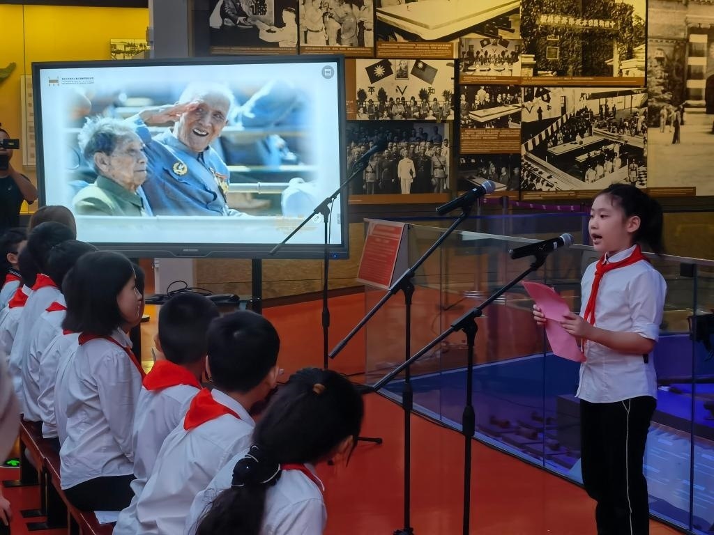 南京市科睿小學(xué)二年級學(xué)生章若初為大家講述抗戰(zhàn)老兵手印的故事。 新華社記者 邱冰清 攝