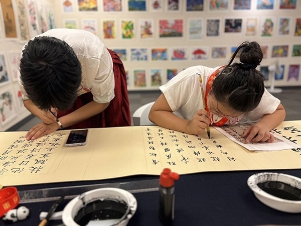 參加本次展覽的青少年在現(xiàn)場進(jìn)行書法創(chuàng)作。主辦方供圖