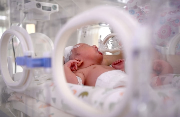 2024年6月1日，在西安國際醫(yī)學(xué)中心醫(yī)院新生兒科病房，護(hù)士為新生兒喂奶。 新華社記者 劉瀟 攝