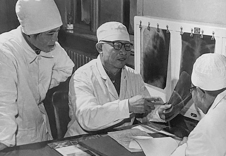 1980年1月16日，中日友好醫(yī)院首任院長辛育齡（中）在內(nèi)蒙古結(jié)核病院與胸外科醫(yī)師討論病例（翻拍照片）。 新華社發(fā)