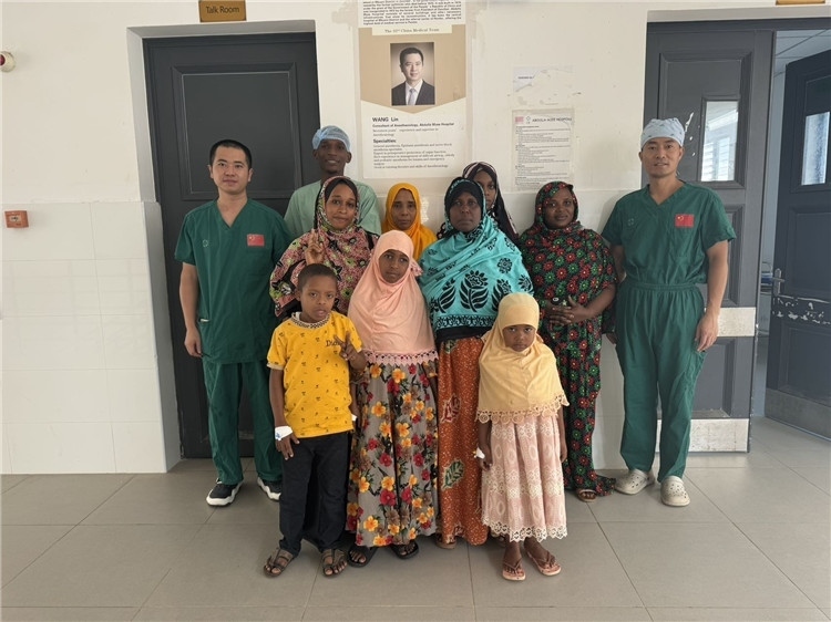 李廣（右一）和王林醫(yī)生與部分患者合影。中國(guó)援桑醫(yī)療隊(duì)供圖