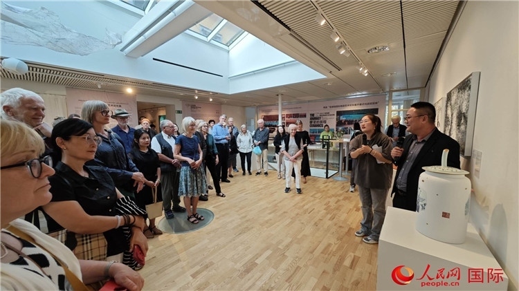 參展人、景德鎮(zhèn)陶瓷大學美術學院副院長邵長宗（右一）向來賓介紹參展作品。人民網(wǎng)記者 殷淼攝