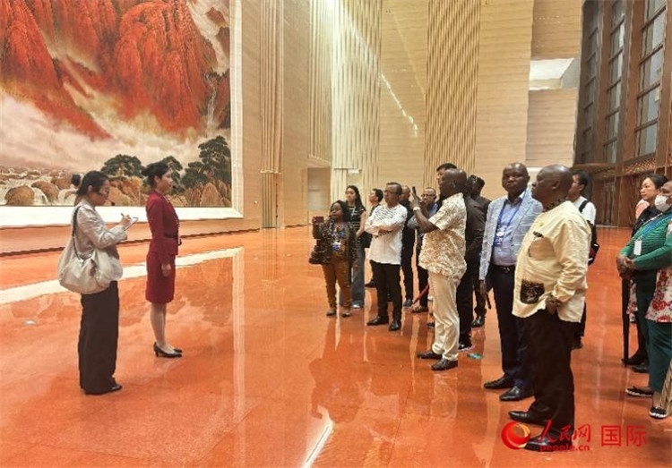 代表團在入口處聽取講解。人民網 曹欣悅攝