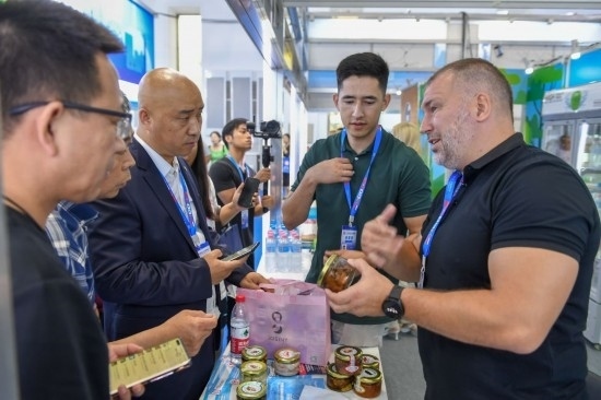 2023年8月23日，在第十四屆中國(guó)—東北亞博覽會(huì)東北亞商品館，俄羅斯參展商向參觀者介紹商品。