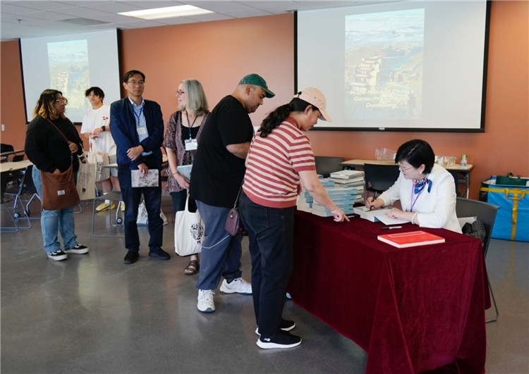 作者顧春芳在活動現(xiàn)場簽名贈書。羅先勇攝