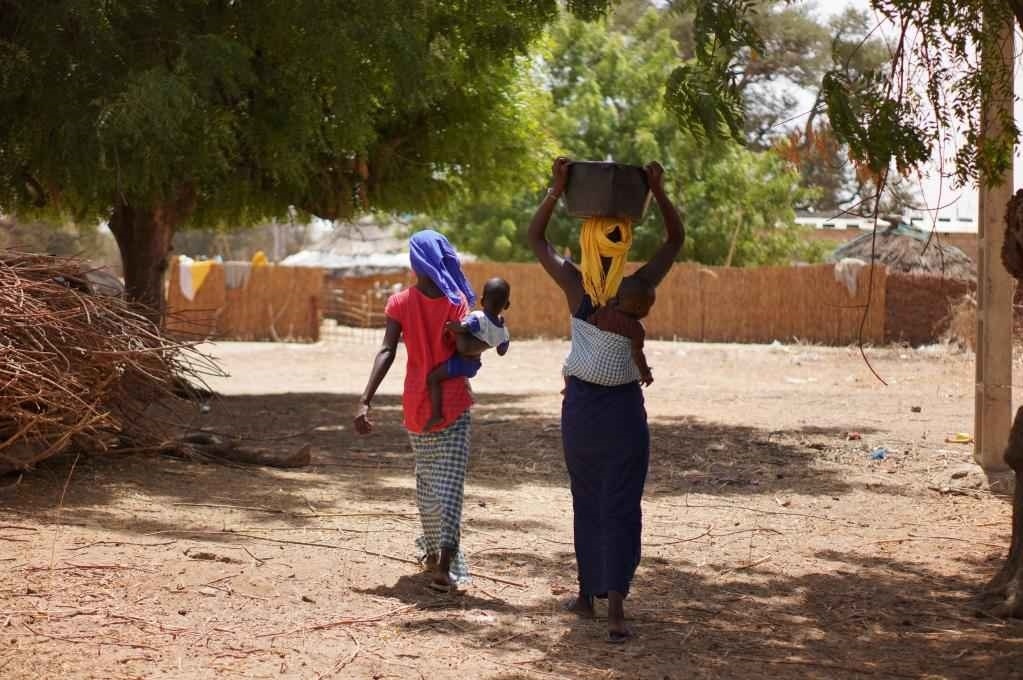 2023年3月20日，在塞內(nèi)加爾久爾貝勒區(qū)的泰內(nèi)富勒村，村民將取到的水運(yùn)回家。新華社記者 王子正 攝