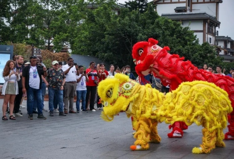 2024“一帶一路”媒體合作論壇聯(lián)合采訪調(diào)研行成員在樂山蘇稽古鎮(zhèn)觀看非遺舞獅表演。本報(bào)記者 伊霄攝