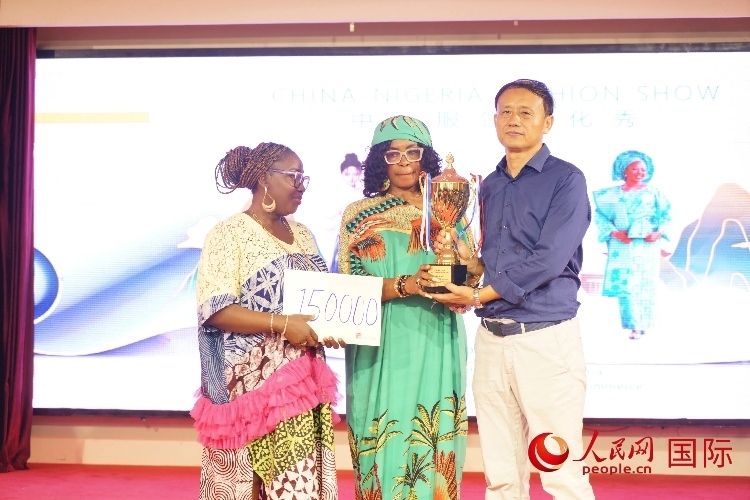 中國(guó)駐尼日利亞使館文化參贊兼中國(guó)文化中心主任李旭大（右）為最佳表現(xiàn)獎(jiǎng)?lì)C獎(jiǎng)（中）。人民網(wǎng)記者 姜宣攝