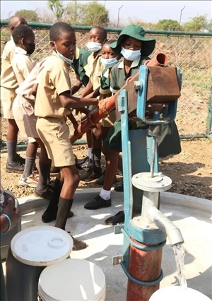 △2021年11月，在津巴布韋南馬塔貝萊蘭省省會關(guān)達(dá)的塞農(nóng)多小學(xué)，學(xué)生從中國援建水井里打水。