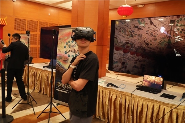 1、在本次活動的展覽現(xiàn)場，敦煌研究院與騰訊展示了“數(shù)字藏經(jīng)洞”和“尋境敦煌”等創(chuàng)新互動產(chǎn)品。圖為當?shù)孛癖娡ㄟ^VR虛擬游覽洞窟。 人民網(wǎng)記者 李志偉攝