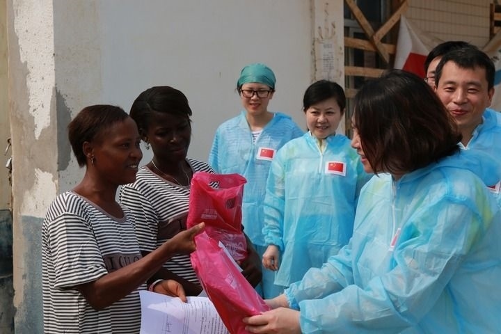 2015年4月4日，在位于塞拉利昂首都弗里敦市郊的中塞友好醫(yī)院埃博拉診療中心，中國第四批援塞醫(yī)療隊副隊長邵蔚（右前）向被治愈的埃博拉出血熱患者贈送禮物。新華社發(fā)（祖榮強 攝）