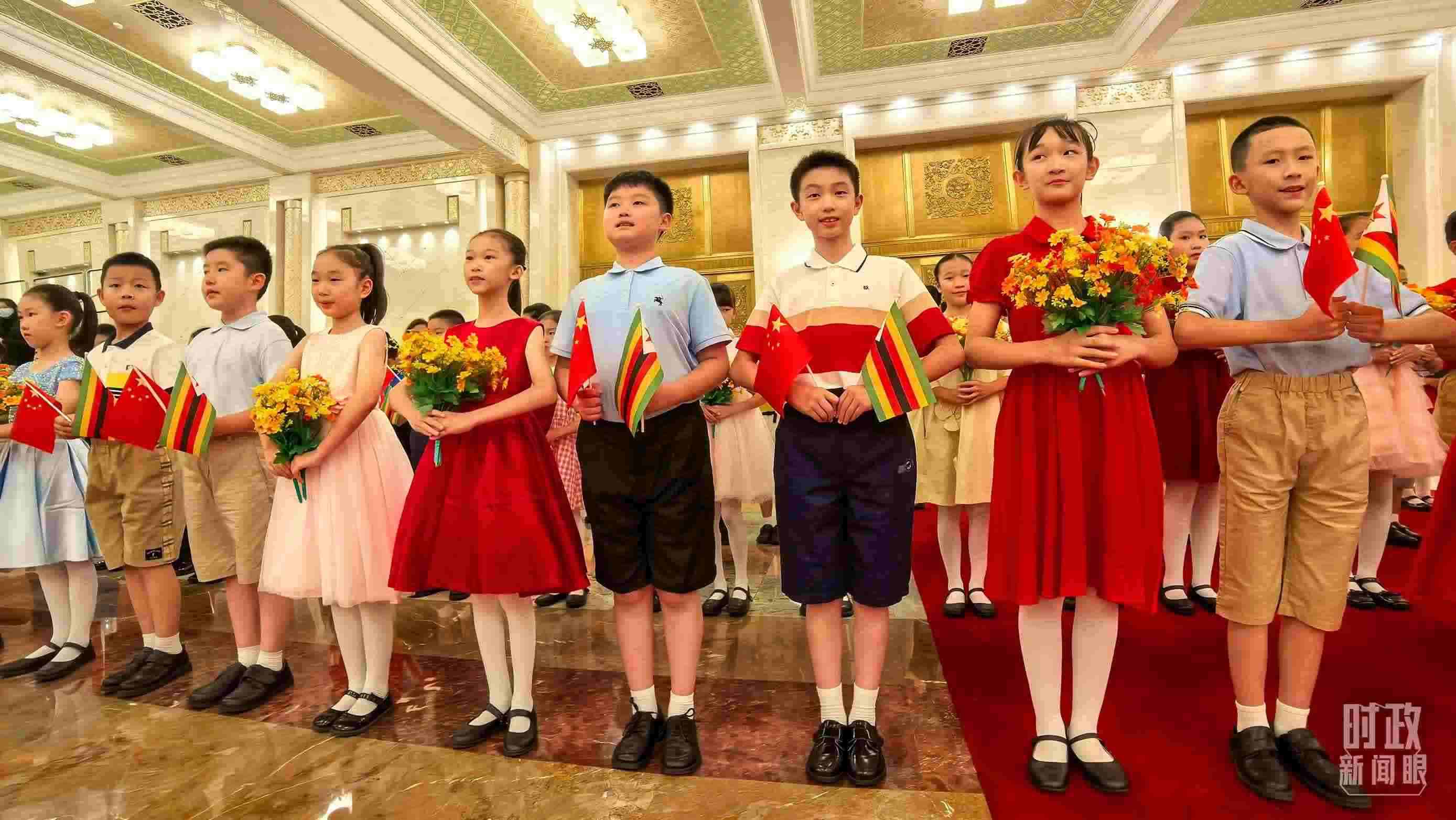 △現(xiàn)場歡迎津巴布韋總統(tǒng)訪華的青少年。（總臺央視記者鐘銳拍攝）