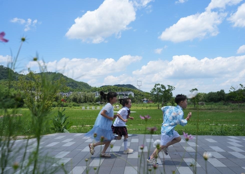 兒童在余姚市梁弄鎮(zhèn)的田野間奔跑（7月3日攝）。新華社記者翁忻旸 攝