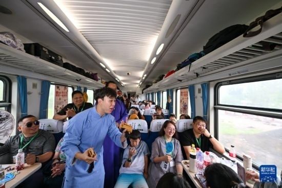 9月7日，相聲演員在S910列車上為旅客表演快板。