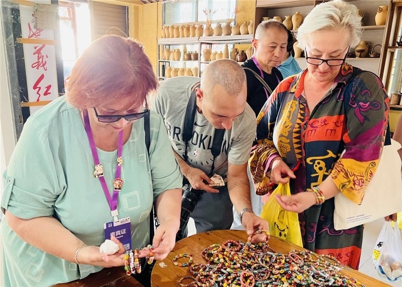 歐亞媒體考察團(tuán)成員在母氏陶藝館內(nèi)挑花了眼，色彩絢麗、質(zhì)地均勻的陶藝手串讓他們愛不釋手?！斑@里的東西都太實惠了！”塔吉克斯坦《索格特真理報》政論部主任娜塔利婭·多羅費(fèi)耶娃說。花茂村的特色產(chǎn)品物美價廉，讓考察團(tuán)成員為家人好友買到了心儀的禮物，也為此次以四川成都為起點，路經(jīng)南充、廣安至貴州遵義的考察行程畫上了圓滿句號。（張亞欣攝）