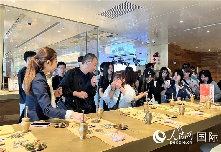 1. 日中友好協(xié)會青年代表團一行學習中醫(yī)香囊制作工序。（人民網(wǎng)記者陳思 攝）