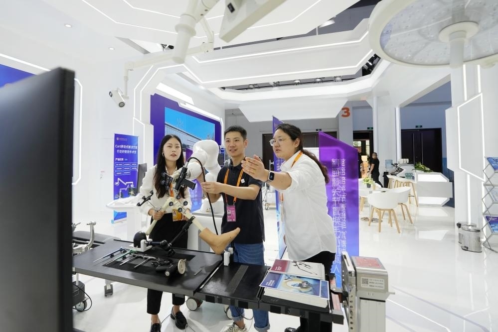 9月11日，一位媒體記者（中）在2024年服貿(mào)會(huì)國家會(huì)議中心會(huì)場體驗(yàn)北京納通科技集團(tuán)有限公司的膝關(guān)節(jié)置換手術(shù)機(jī)器人。新華社記者鞠煥宗 攝