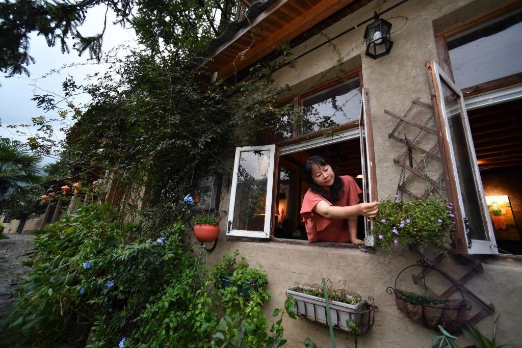 8月29日，在福建省屏南縣熙嶺鄉(xiāng)，龍?zhí)洞濉靶麓迕瘛泵泛暝诖蚶碜约航?jīng)營的民宿外墻裝飾花盆。新華社記者姜克紅 攝