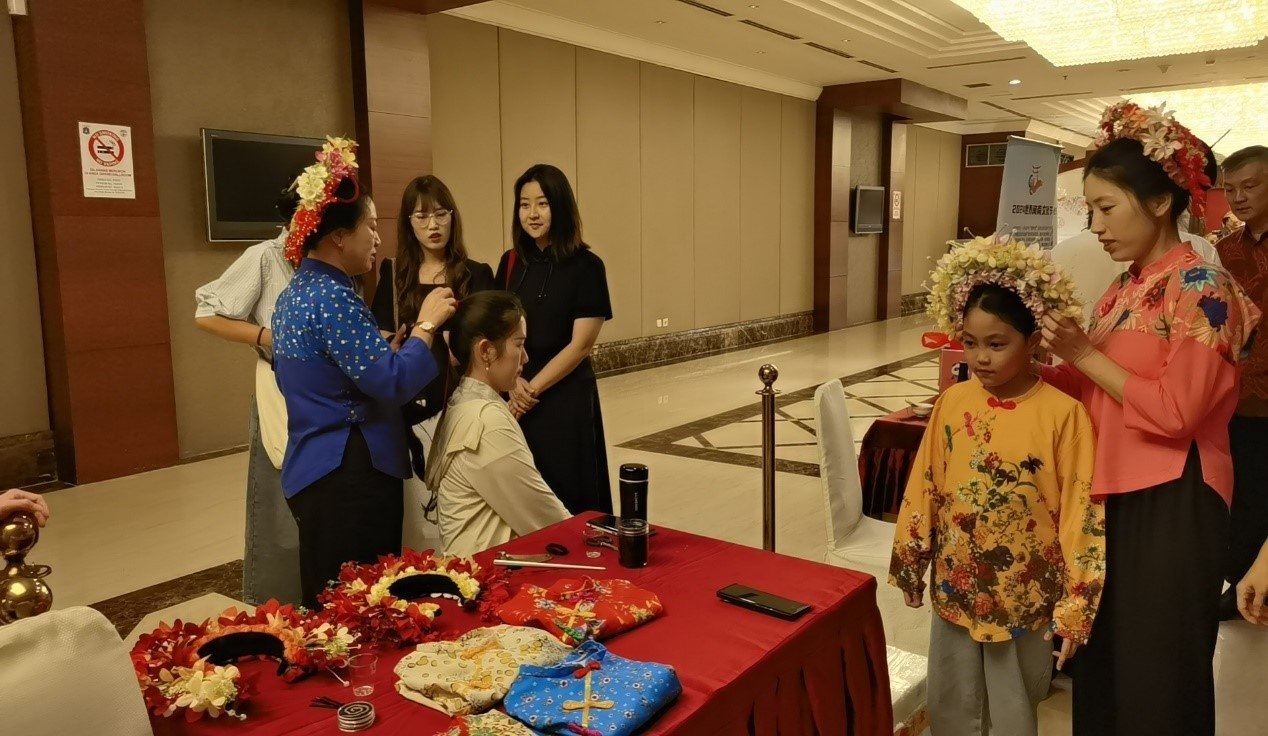 阿拉扎大學(xué)孔子學(xué)院志愿者老師向傳承人學(xué)習簪花圍。阿拉扎大學(xué)孔子學(xué)院供圖