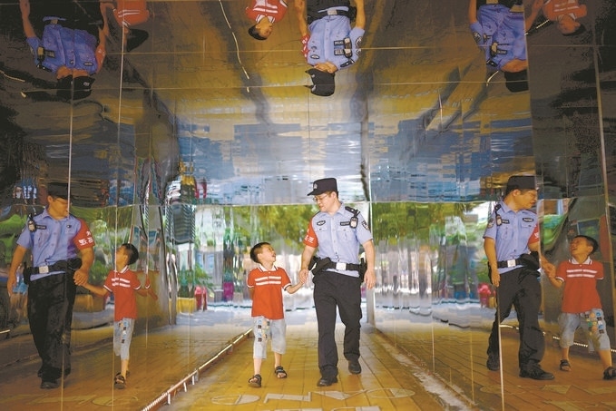 ?7月16日，重慶市公安局江北區(qū)分局一名民警在巡邏途中遇到一個獨自玩耍的小男孩，民警將其送回家。王洪平攝