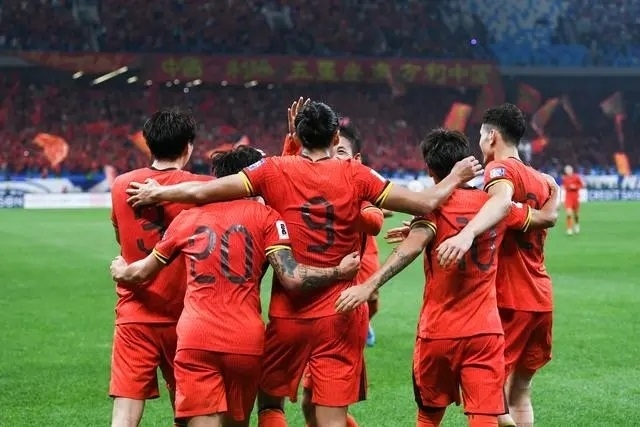 10月15日晚，張玉寧（9號(hào)）進(jìn)球后與隊(duì)友擁抱慶祝。新華社記者 李紫恒攝