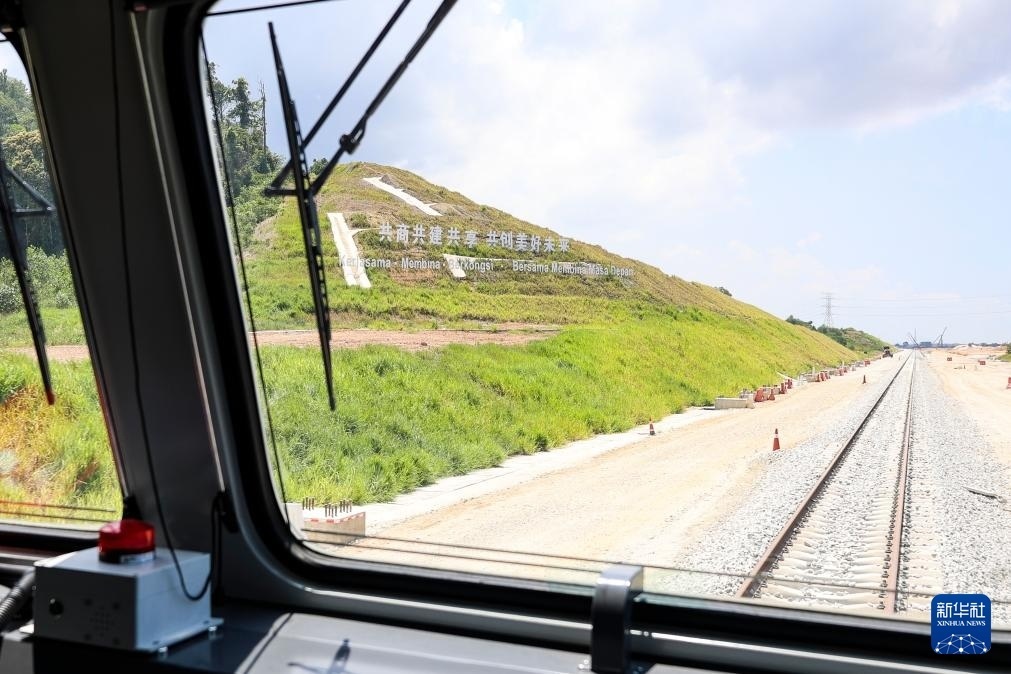 5月6日，在馬來西亞彭亨州馬東鐵項(xiàng)目沿途的山坡上，兩行中文和馬來文大字“共商共建共享，共創(chuàng)美好未來”映入眼簾。新華社記者 程一恒 攝