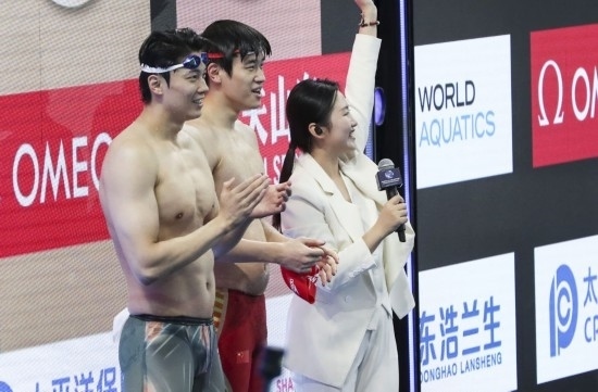  10月18日，汪順（左）和潘展樂在男子100米混合泳決賽后。新華社記者 方喆 攝