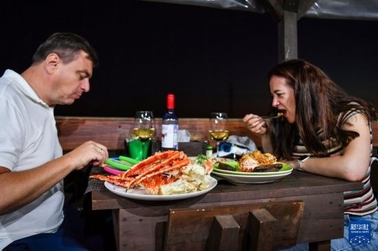 9月2日，食客們在俄羅斯符拉迪沃斯托克的一家餐館品嘗帝王蟹。新華社記者 曹陽 攝
