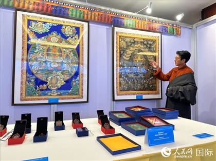 熱貢藝術(shù)國家級(jí)代表性傳承人夏吾角向嘉賓介紹作品。人民網(wǎng)記者 簡承淵攝