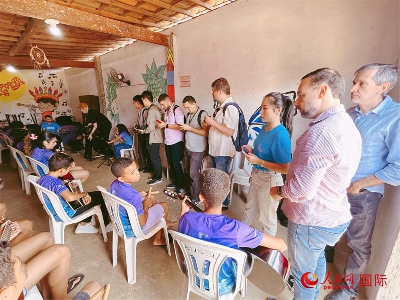  受益于中國企業(yè)的“青少年成長”項目，700多名當(dāng)?shù)厍嗌倌甑囊魳泛妥闱驂粝氩迳狭顺岚颉D為聯(lián)合采訪團正在采訪參加音樂培訓(xùn)的孩子們。 人民網(wǎng)記者 陳一鳴攝