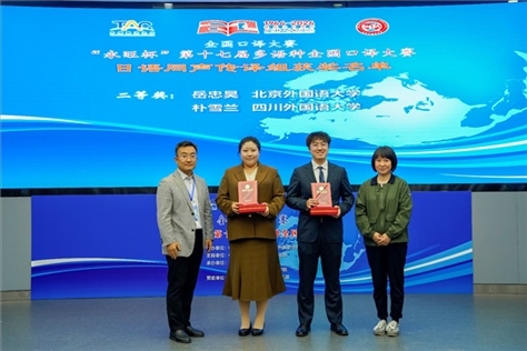 外交部亞洲司參贊張梅（右一）、中聯(lián)部副局長沈建國（左一）為獲得日語同傳組二等獎(jiǎng)的北京外國語大學(xué)岳忠昊、四川外國語大學(xué)樸雪蘭頒獎(jiǎng)（主辦方提供）