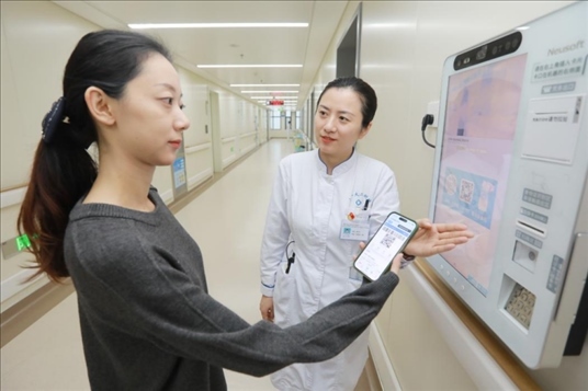 醫(yī)護人員引導(dǎo)患者在自助機前辦理自助入院手續(xù)。圖片來源：山東第一醫(yī)科大學(xué)第二附屬醫(yī)院