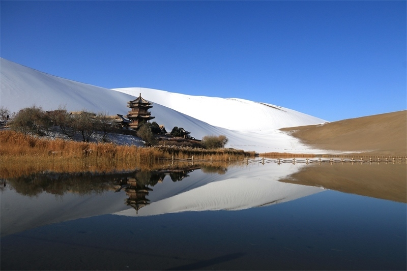 鳴沙山月牙泉景區(qū)雪景。敦煌市委宣傳部供圖，張曉亮攝