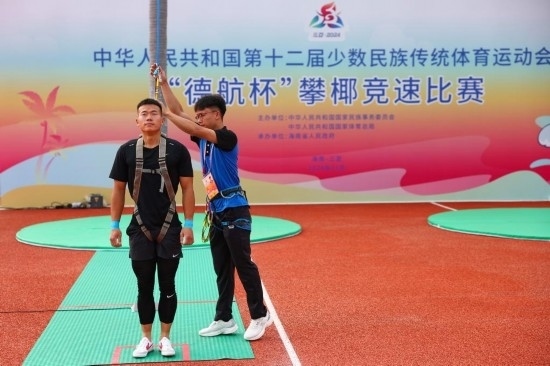 11月23日，工作人員為上海隊(duì)選手付樂樂（左）系安全繩。新華社記者 楊植森 攝