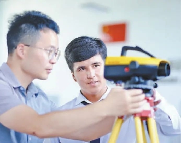 在塔吉克斯坦首都杜尚別的魯班工坊，來自天津城市建設(shè)管理職業(yè)技術(shù)學(xué)院的老師（左）為當(dāng)?shù)貙W(xué)生提供指導(dǎo)。新華社記者 鄭開君 攝