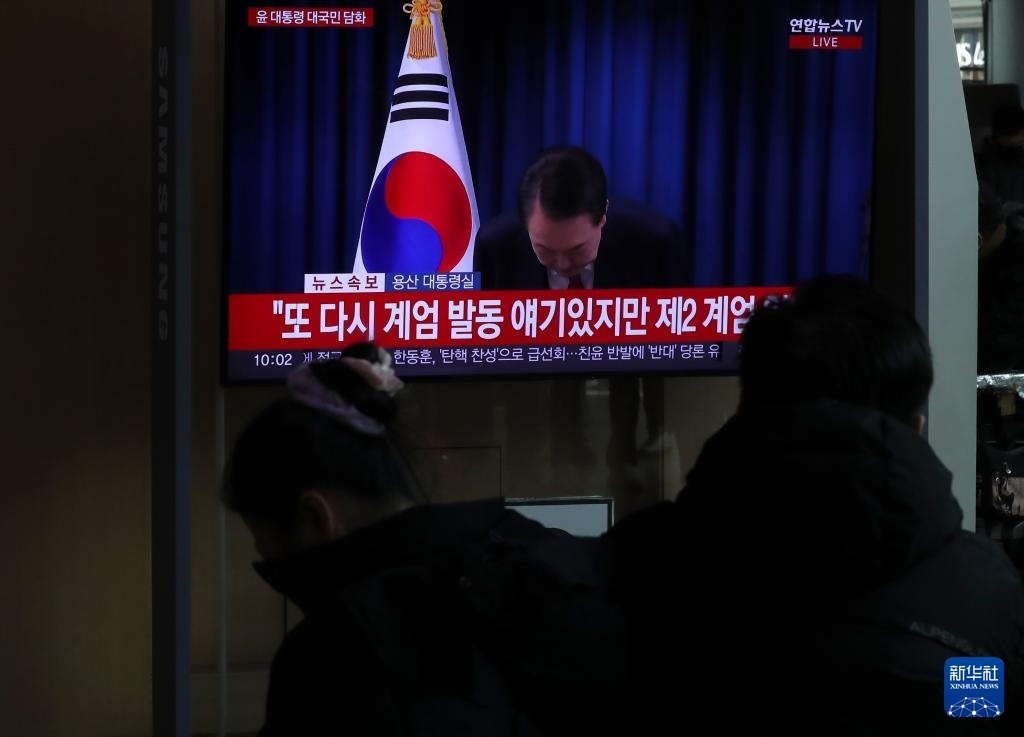 12月7日，在韓國首爾火車站，民眾觀看總統(tǒng)尹錫悅發(fā)表講話的電視畫面。新華社記者 姚琪琳 攝