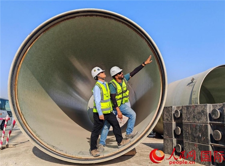 工作人員在察看輸水管情況。人民網(wǎng)記者 管克江攝