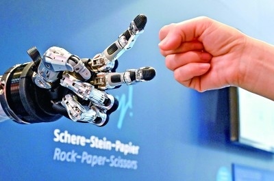 在德國(guó)漢諾威工博會(huì)上，參觀者與一款智能機(jī)器人進(jìn)行“石頭剪子布”游戲。新華社發(fā)