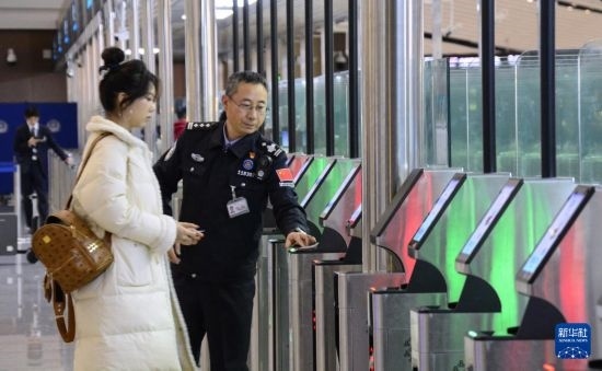 1月2日，大興機場邊檢站警察指導(dǎo)旅客使用自助出境設(shè)備。新華社記者 李欣 攝