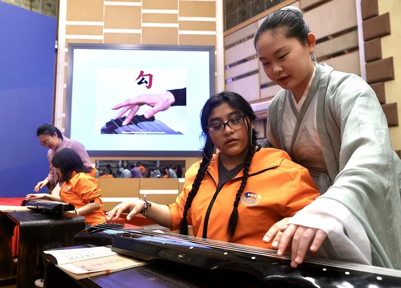 2024年3月20日，美國華盛頓州中學生代表團北京大學交流活動在北京大學英杰交流中心舉行。圖為來自華盛頓州的中學生體驗古琴。