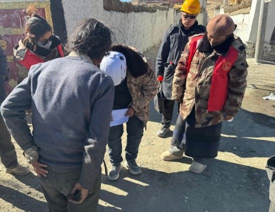 1月13日，次旺（右一）陪同工作組走訪村莊，評(píng)估房屋受損程度。新華社發(fā)