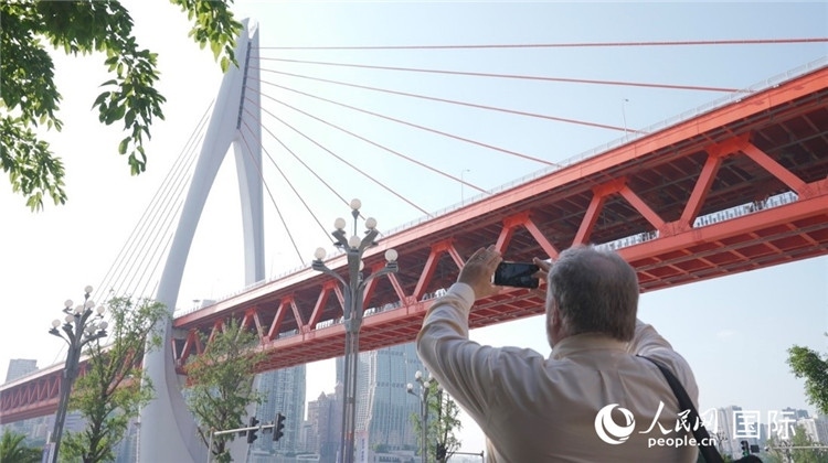 軻寶華“打卡”重慶東水門長江大橋。人民網(wǎng)記者 蘇纓翔攝