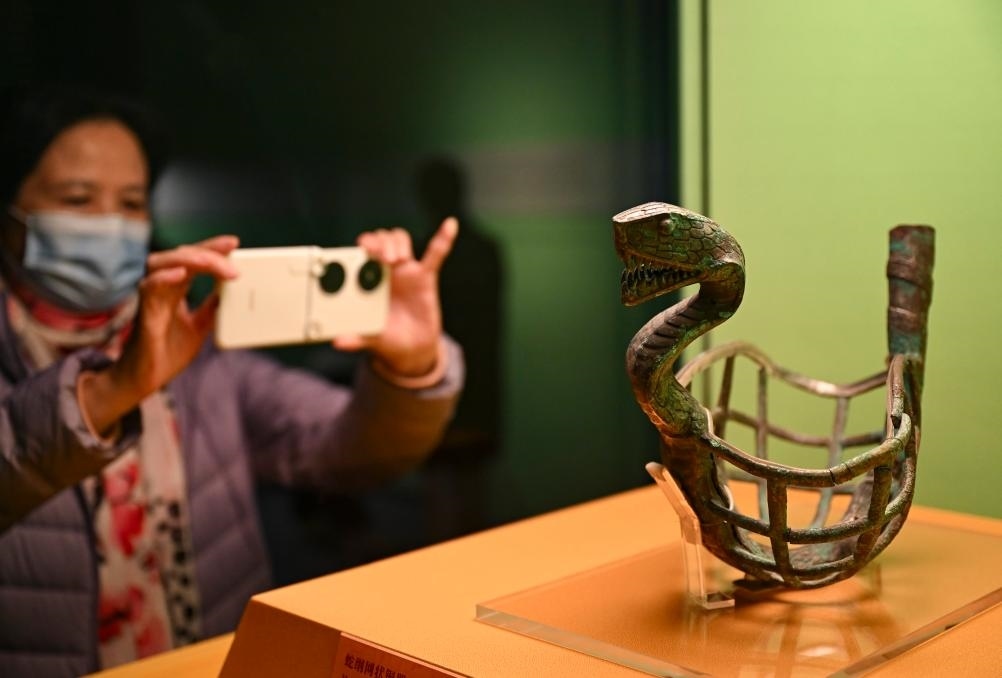 1月14日，觀眾在上海博物館蛇年迎春展拍攝展品蛇綱網狀銅器。新華社發(fā)（陳浩明攝）
