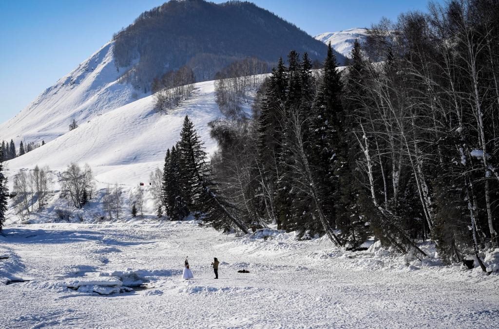 2024年2月5日，兩名游客在新疆阿勒泰地區(qū)布爾津縣禾木村拍照。新華社記者 馬鍇 攝